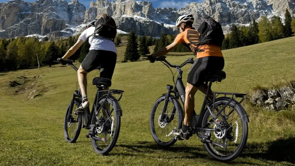 Pessoas usando bicicleta elétrica em trilha e área de lazer
